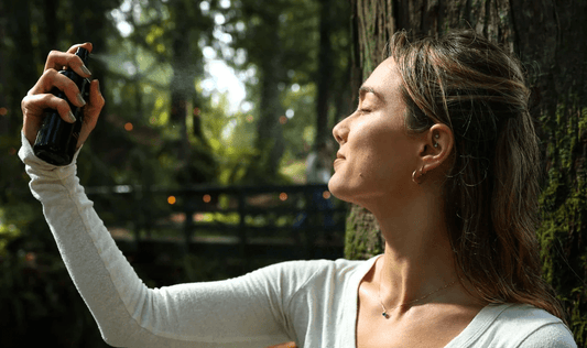 A woman spritzes a facial mist on her face. What are the top benefits of facial mist? Learn more in our comprehensive guide.