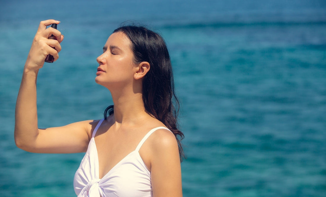 A woman sprays her face with a face toner. If you've ever wondered if toner comes before or after moisturizer, check out our guide for all the tips.