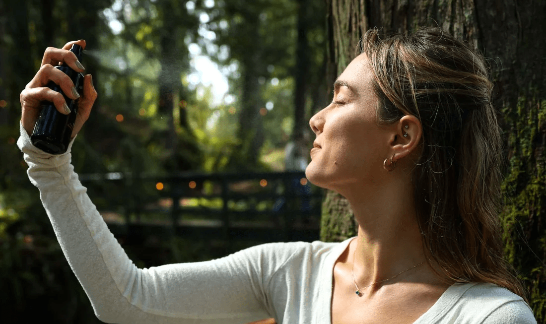 A woman spritzes a facial mist on her face. What are the top benefits of facial mist? Learn more in our comprehensive guide.