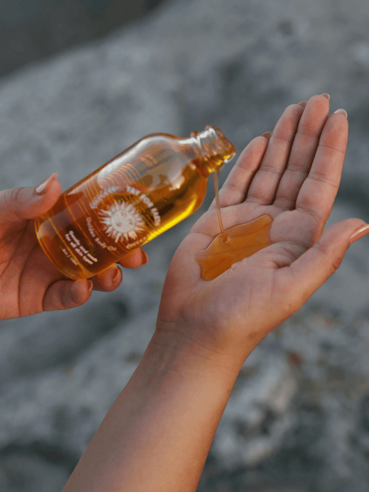 A detail photo of Yay for Earth's Golden Face and Body Oil being poured into a woman's palm. Explore our minimal skincare routine, ditch the extra products, save money, and get better results today.